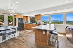 Kitchen featuring black refrigerator with ice dispenser, a peninsula, a sink, healthy amount of natural light, and recessed lighting
