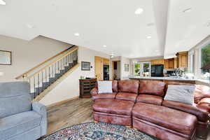 Living room featuring light wood finished floors, stairway, recessed lighting, and baseboards