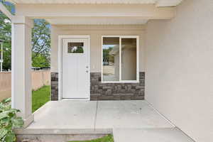 Property entrance with stone siding and stucco siding