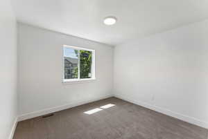 Carpeted empty room featuring baseboards