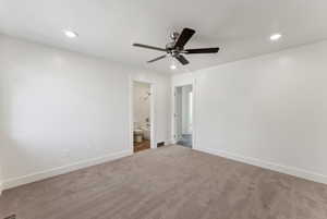 Unfurnished bedroom with recessed lighting, baseboards, carpet, ensuite bathroom, and a ceiling fan
