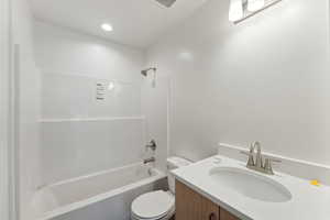 Full bathroom featuring toilet, shower / bath combination, and vanity