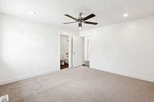 Unfurnished bedroom with dark carpet, ensuite bathroom, recessed lighting, and a ceiling fan