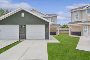 Traditional-style house with driveway, stucco siding, and a front yard