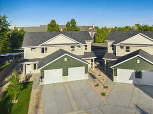 Traditional-style house featuring a residential view, stucco siding, a garage, concrete driveway, and roof with shingles
