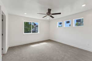 Unfurnished room with healthy amount of natural light, carpet floors, baseboards, and recessed lighting