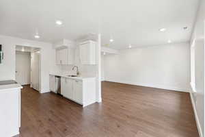 Kitchen featuring white cabinets, recessed lighting, dark wood-style flooring, dishwasher, and light stone counters