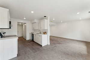 Kitchen featuring black dishwasher, a sink, stove, stainless steel microwave, and light countertops