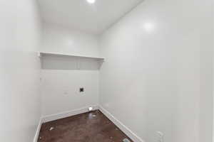 Laundry room with hookup for an electric dryer, baseboards, and dark wood-style flooring