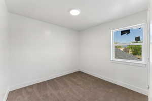 Empty room featuring carpet and baseboards
