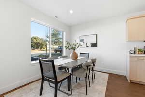 Dining space with dark wood-type flooring and recessed lighting