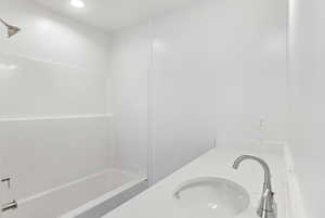 Bathroom with  shower combination, double vanity, and recessed lighting