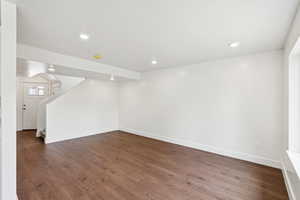 Below grade area featuring dark wood-type flooring, stairway, and recessed lighting