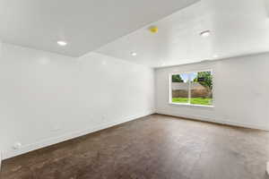 Empty room featuring baseboards, a smoke detector, and recessed lighting