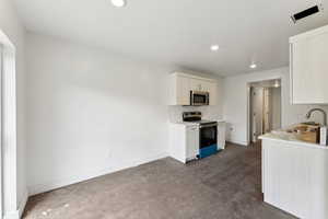 Kitchen featuring stainless steel appliances, a sink, light countertops, baseboards, and recessed lighting