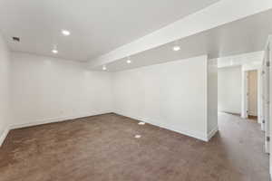 Unfurnished room featuring concrete flooring, baseboards, and recessed lighting