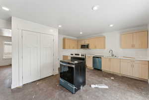 Kitchen with light brown cabinets, stainless steel appliances, a sink, concrete flooring, and recessed lighting