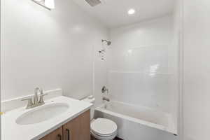 Full bath featuring toilet, vanity, washtub / shower combination, and recessed lighting