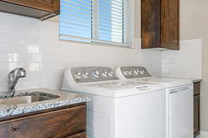 Washroom featuring washing machine and clothes dryer and cabinet space