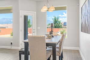 Dining space featuring wood finished floors, baseboards, a mountain view, and a chandelier
