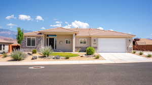 Prairie-style house with stone siding, stucco siding, a tiled roof, and an attached garage