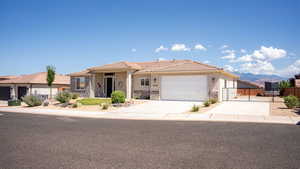 View of front of house with stone siding, stucco siding, a gate, and concrete driveway