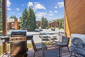 Wooden terrace with area for grilling, ac unit, and a residential view