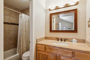 Full bath featuring vanity, toilet, and shower / bath combo with shower curtain