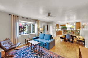 Living area with ceiling fan and baseboards