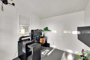 Carpeted office space featuring cooling unit and baseboards