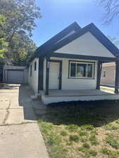 View of front of property with covered porch, driveway, a garage, and stucco siding