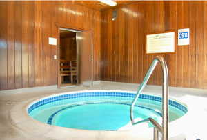 View of swimming pool with a hot tub