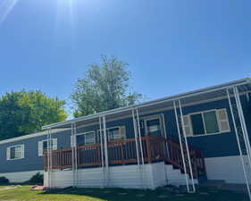 Manufactured / mobile home with a porch and a front lawn
