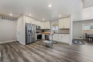 Kitchen featuring appliances with stainless steel finishes, baseboards, dark wood-type flooring, recessed lighting, and backsplash