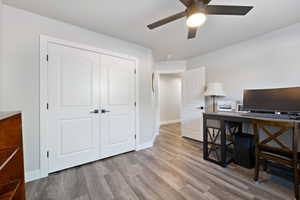 Home office with wood finished floors, ceiling fan, and baseboards