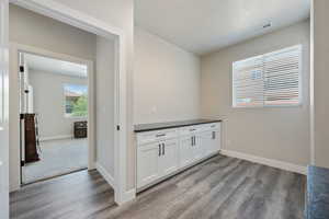 Bar with wood finished floors and baseboards