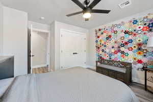 Bedroom with wood finished floors, baseboards, and a closet