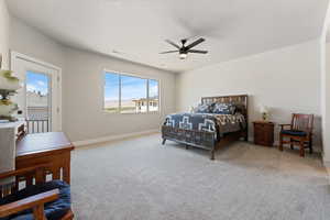 Carpeted bedroom with multiple windows, baseboards, and a ceiling fan
