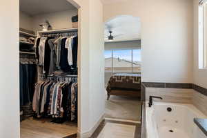 Walk in closet featuring arched walkways and a ceiling fan