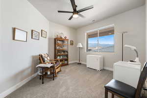 Office area featuring ceiling fan, light colored carpet, and baseboards