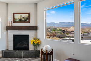 Living room featuring a mountain view, wood finished floors, a tiled fireplace, and baseboards