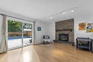 Family room with track lighting, and a stone fireplace.