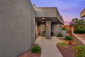 Exterior entry at dusk featuring stucco siding