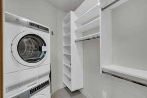 Laundry room with stacked washer / drying machine and light tile patterned floors