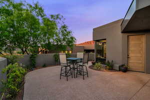Patio terrace at dusk with outdoor dining space and a patio