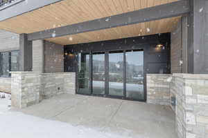 Property entrance featuring stone siding and a patio
