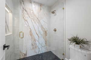 Full bathroom with a stall shower and toilet