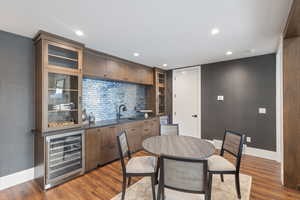Indoor wet bar with beverage cooler, baseboards, dark wood finished floors, and recessed lighting