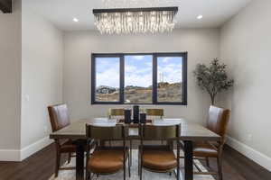 Dining space with baseboards, wood finished floors, a chandelier, and recessed lighting