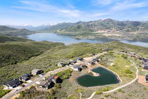 Aerial overview of property's location featuring a water and mountain view and nearby suburban area